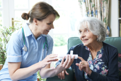 Caregiver giving medicine to an elder