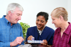 Nurse showing medicines to the elders