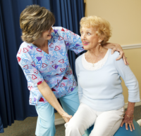 Caregiver and elder doing physical therapy